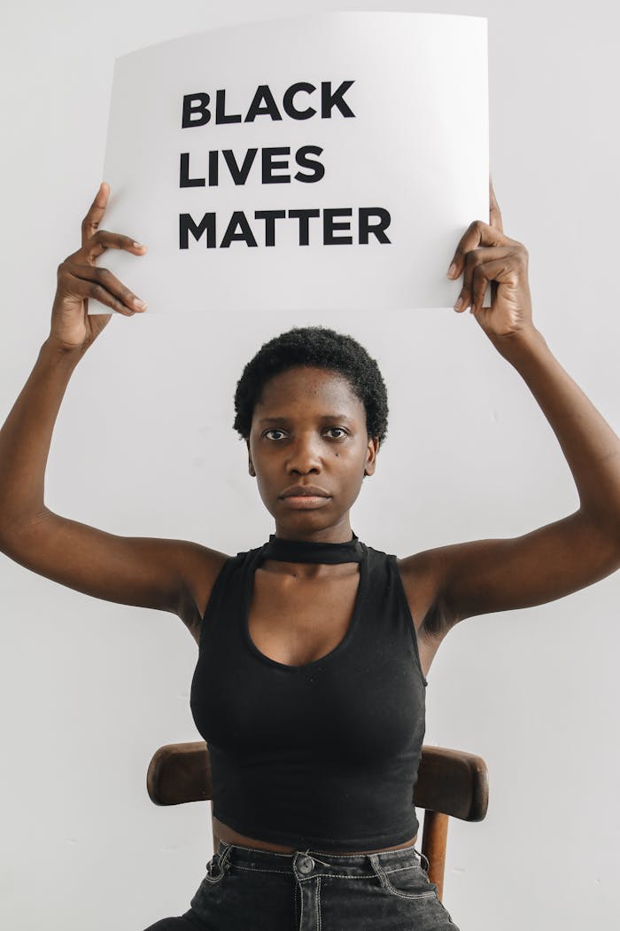 Young black woman holding a Black Lives Matter sign, advocating for racial equality.